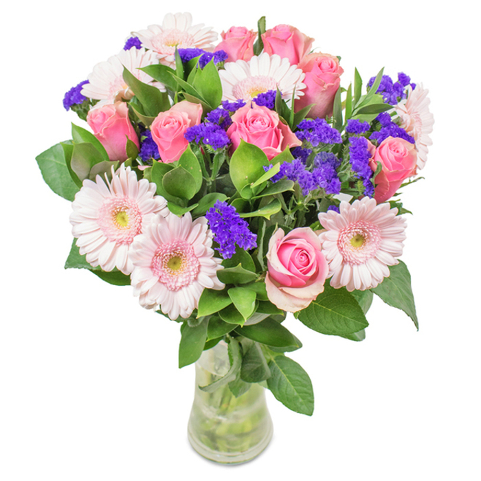 Standing elegantly against a crisp white backdrop, this luxurious bouquet rests in a tall, clear glass vase, capturing the fresh vibrancy celebrated by Forest Hill Flowers. A harmonious grouping of approximately eight soft pink roses, some tightly furled, share centre stage with six pale pink gerbera daisies, their round heads and almost silvery centres creating visual harmony and volume. Lavender-hued statice or limonium weaves throughout, its vivid colour offering rich contrast and tactile depth. The composition is grounded with abundant, deep green foliage that calls to mind the leafy avenues of Forest Hill and the peaceful greenery surrounding One Tree Hill. The visible stems and water further the bouquet's aesthetic of freshly gathered abundance and local natural beauty. Crafted for memorable occasions-from birthdays to anniversaries, or simply to bring a smile on a visit to Sunderland Road-this arrangement expresses joy and thoughtful affection. Whether delivered the same day or a planned surprise, every element resonates with the experience and care shown by Forest Hill Flowers, transforming everyday moments into celebrations.